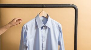 person reaching for a dress shirt