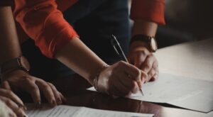 people signing paperwork