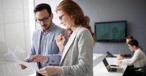 People in professional attire talking about papers