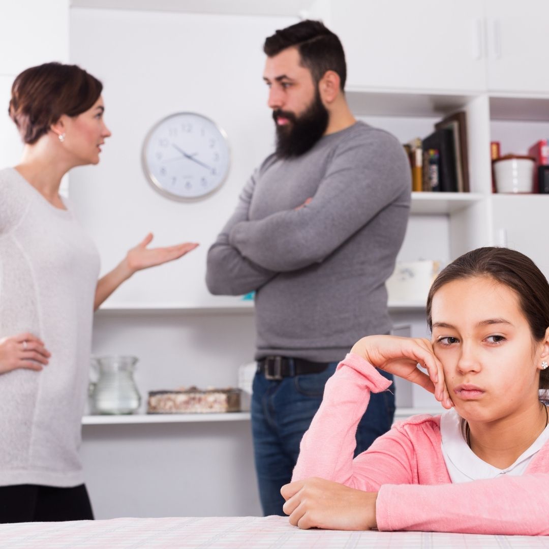 parents arguing while child looks distraught