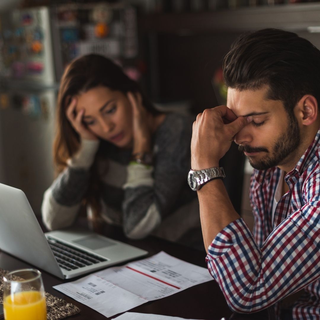 man and woman looking at bills